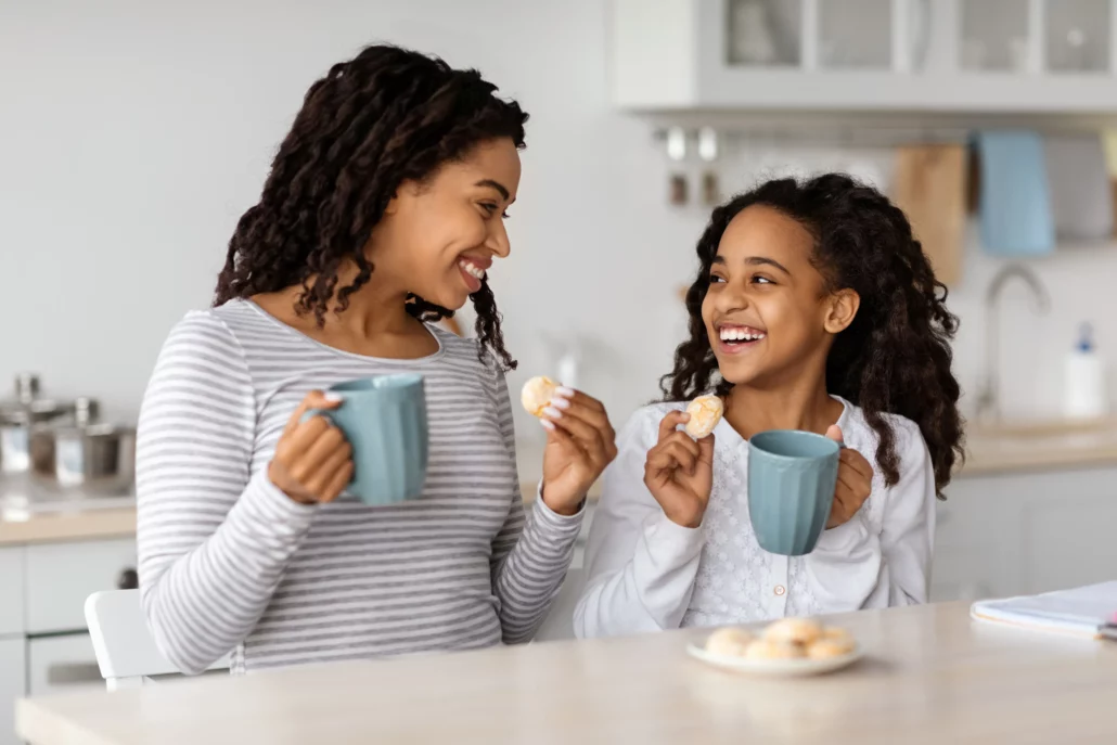 Mom and daughter having tea and cookies